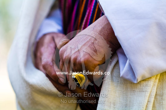 An ornate brass ring on the finger of a Buddhist visiting a monastery. Rinpung Dzong, Paro Dzong, Paro, Paro District, Bhutan.