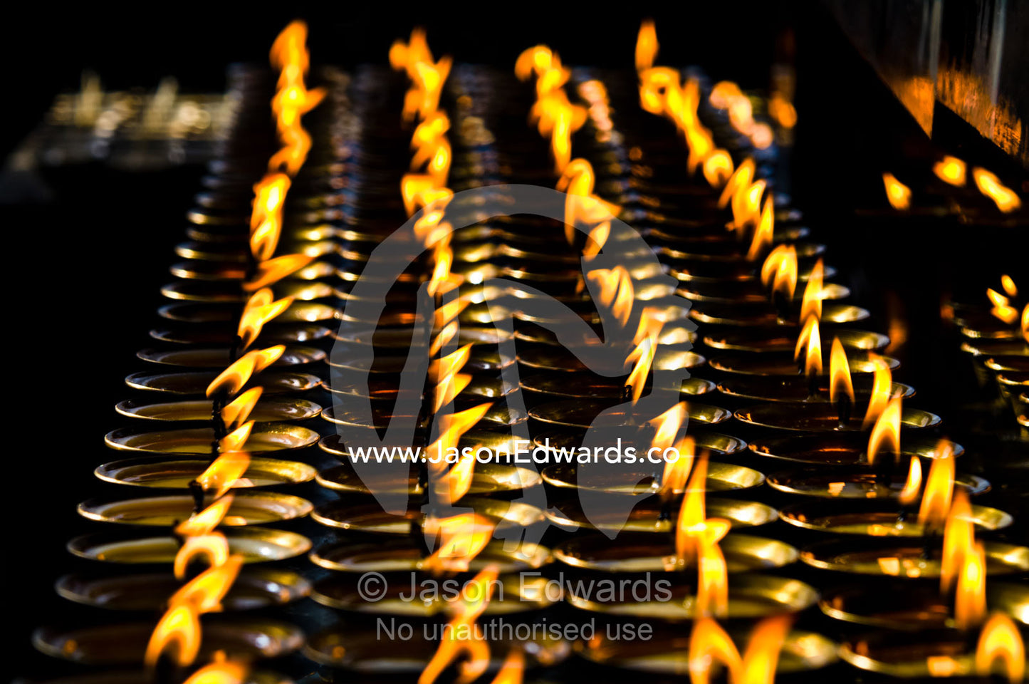Flames burn in rows of butter lamps for prayers and aspirations at the Thimphu Memorial Chorten. Thimphu Memorial Chorten, Thimphu, Bhutan.