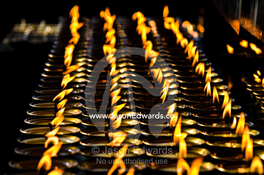 Flames burn in rows of butter lamps for prayers and aspirations at the Thimphu Memorial Chorten. Thimphu Memorial Chorten, Thimphu, Bhutan.