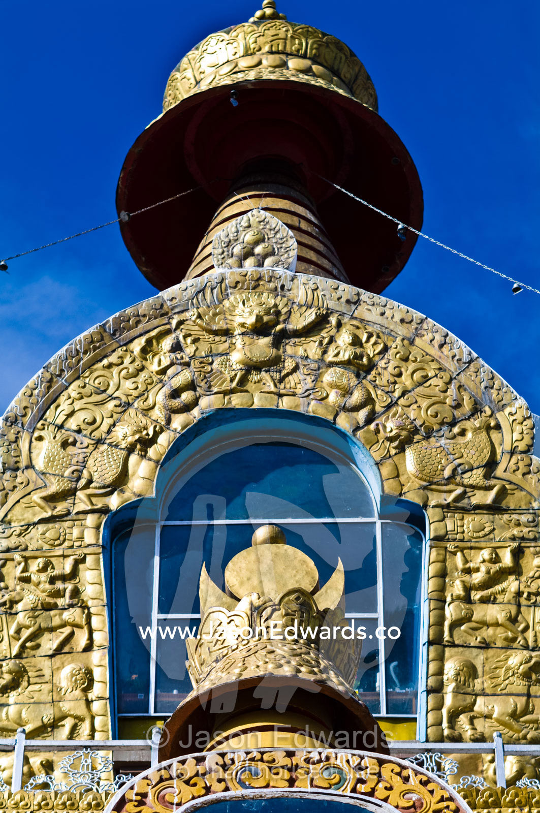 Sunlight enters a window beneath the golden spire of the Thimphu Memorial Chorten. Thimphu Memorial Chorten, Thimphu, Bhutan.
