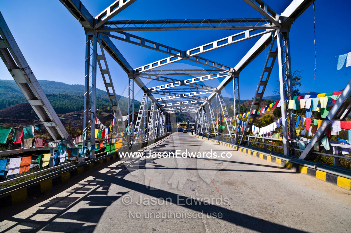 Prayer flags hanging from the steel girders of a bridge crossing the Paro River. Paro Chu, Paro River, Paro, Paro District, Bhutan.