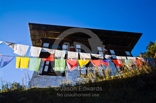 Colorful prayer flags on the mountain path to a Buddhist monastery in the Himalaya. Cheri Monastery, Chagri Dorjeden Monastery, Thimphu, Thimphu District, Bhutan.