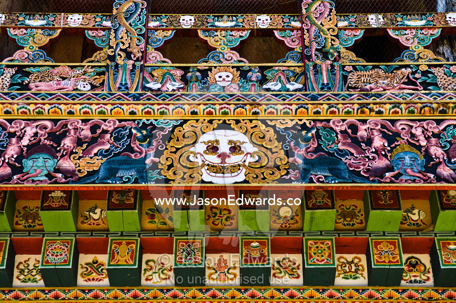 An ornately crafted and painted skull on a mural beneath the eave of a Buddhist monastery. Gangteng Monastery, Ganteng, Wangdue Phodrang District, Phobjika Valley, Phobjikha Valley, Gangteng Valley, Black Mountains, Bhutan.
