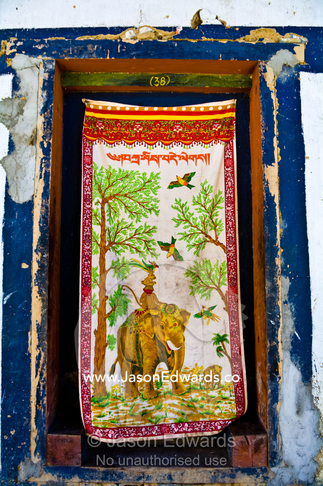 A silk wall hanging featuring an Asian Elephant forms a makeshift door to a Buddhist monk's bedroom. Gangteng Monastery, Ganteng, Wangdue Phodrang District, Phobjika Valley, Phobjikha Valley, Gangteng Valley, Black Mountains, Bhutan.