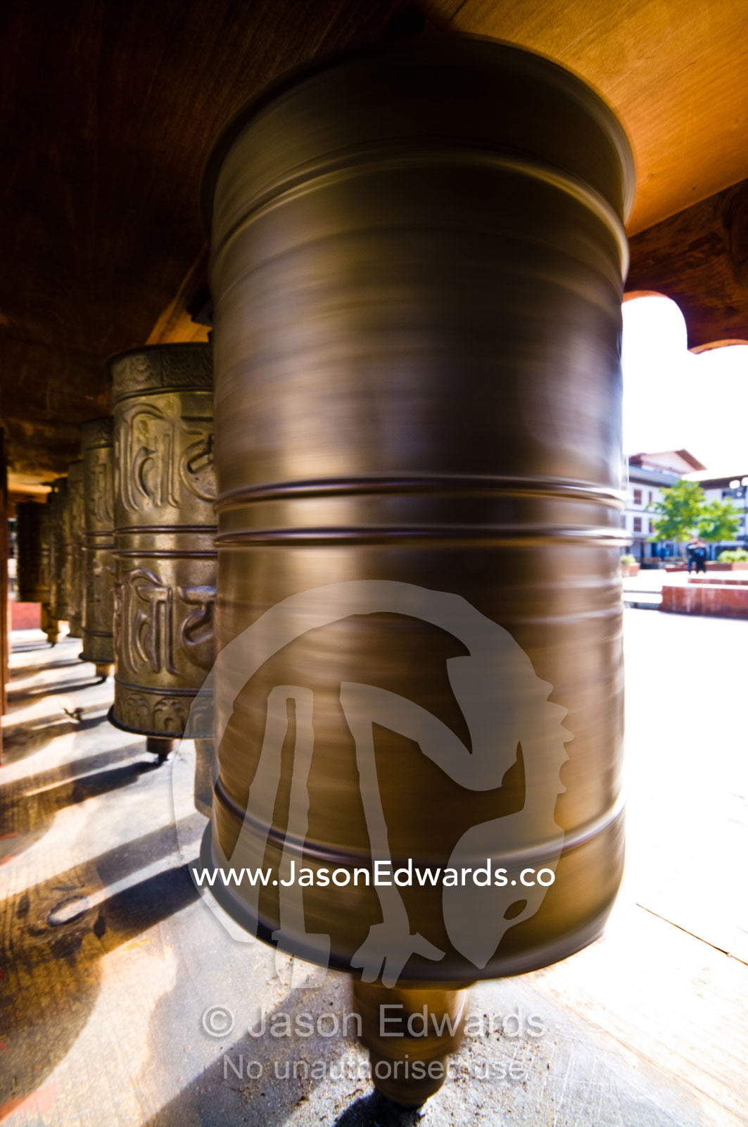 Religious symbols on a spinning brass prayer wheel in a Himalayan town square. Thimphu, Thimphu District, Bhutan.