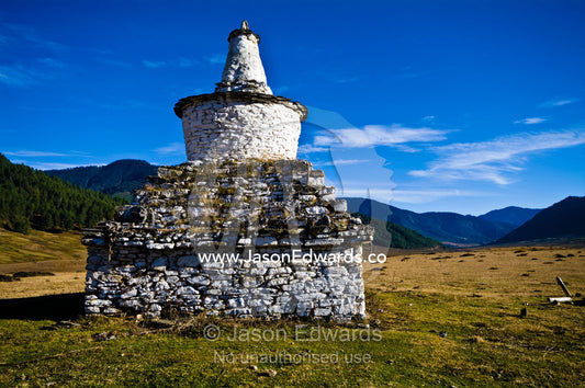 Grass grows between the stones of an ancient chorten overlooking a Himalaya wetland. Phobjikha Conservation Area, Phobjika Valley, Phobjikha Valley, Gangteng Valley, Black Mountains, Bhutan.
