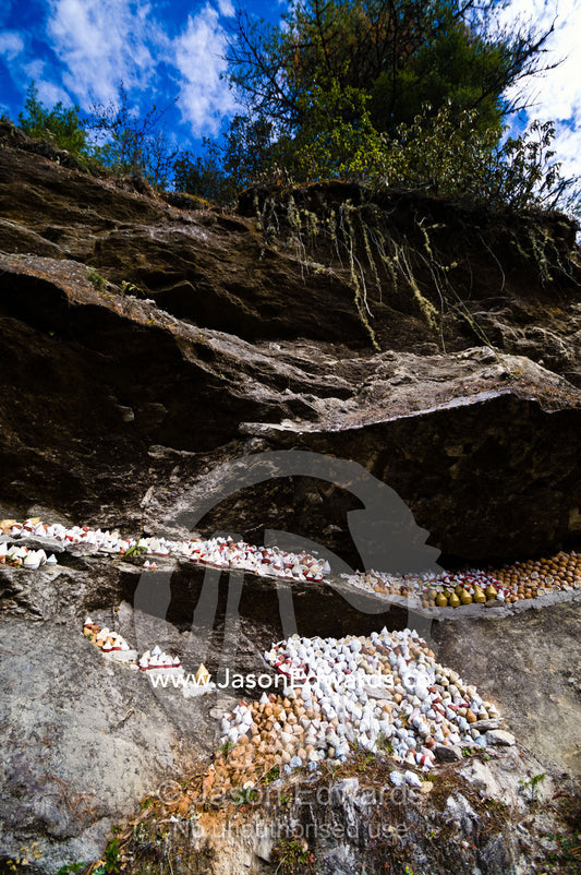 People place religious reliquaries or tsa tsa on a cliff in a Himalaya valley in memory of deceased loved ones. Dochula Pass, Thimphu District, Bhutan.