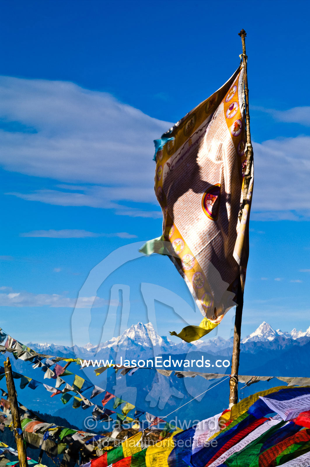 A shiny gold and bronze embossed flag on a Himalayan mountaintop. 108 Druk Wangyal Khangzang Chortens, Dochula Pass, Thimphu District, Bhutan.