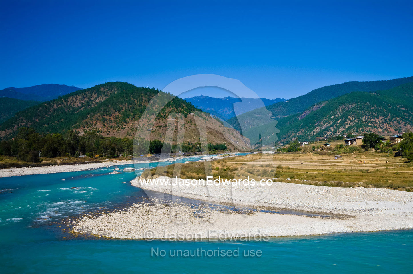 A pristine turquoise alpine river flowing around a river-bend in a Himalaya valley. Punakha District, Bhutan.