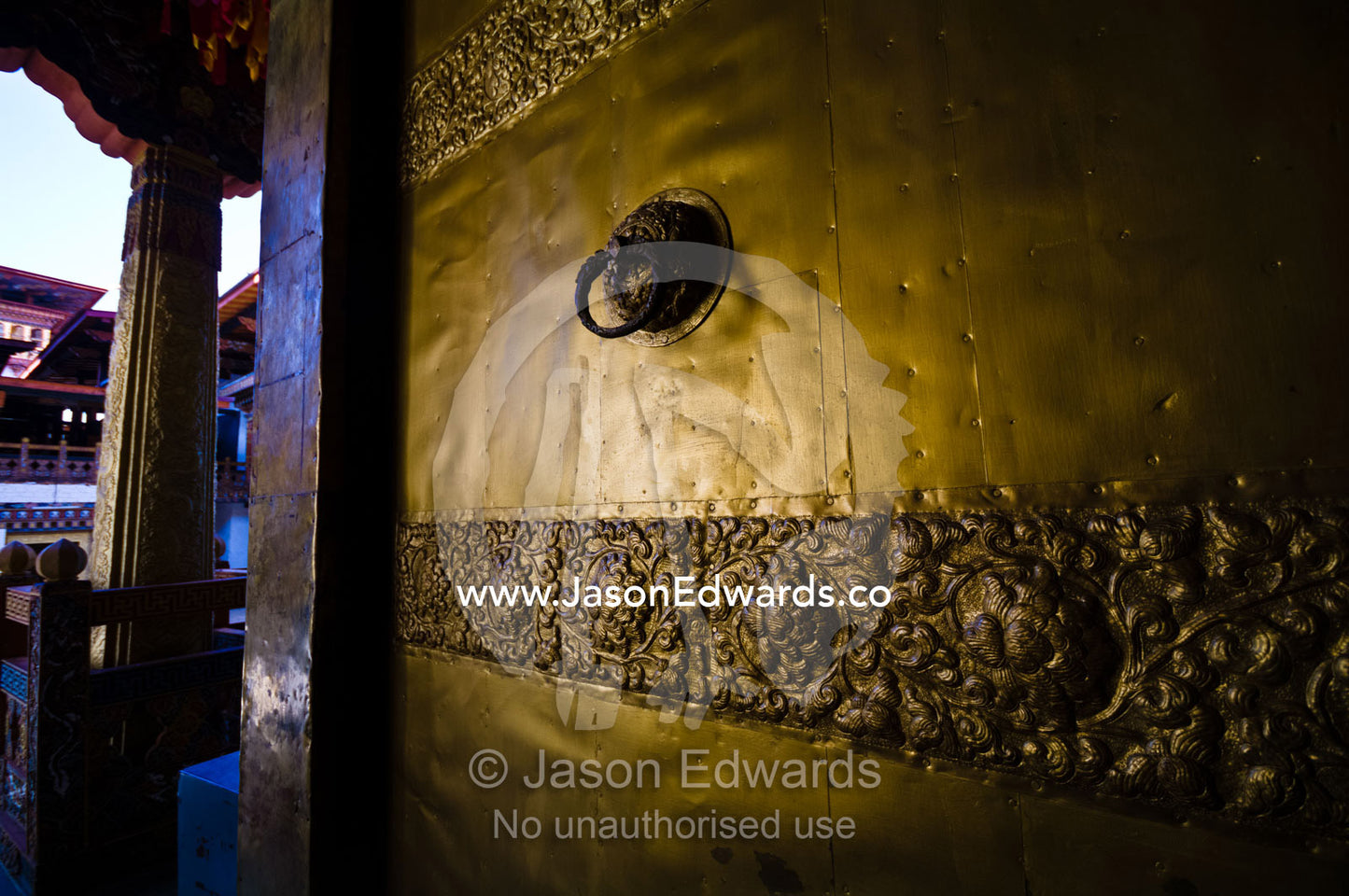 An ornately carved brass door and knocker in an ancient Buddhist monastery. Punakha Dzong, Punakha dzongkhag, Punakha District, Bhutan.