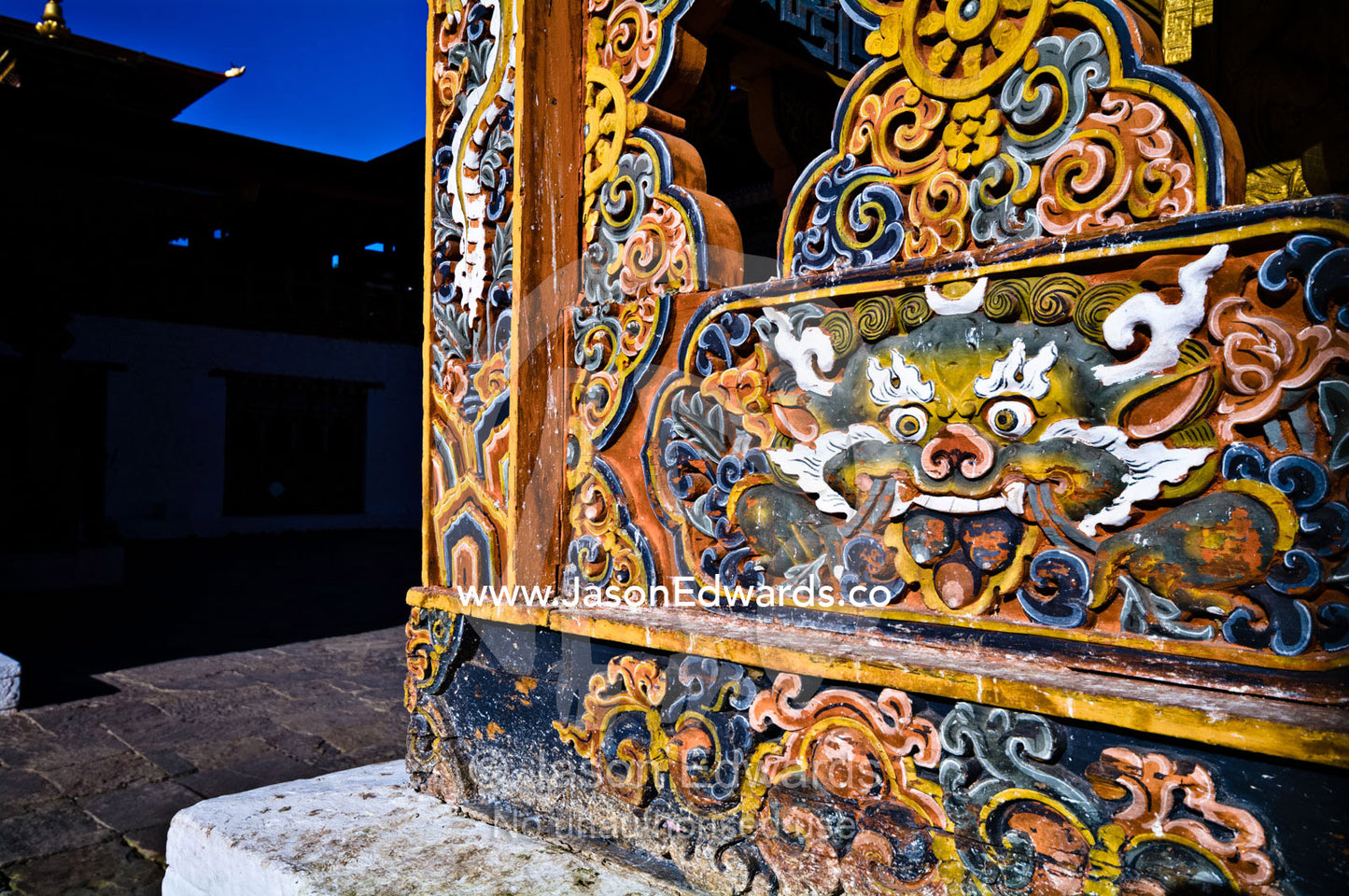 A colorful and intricate carving of a Snow Lion on the wall of an ancient Buddhist monastery. Punakha Dzong, Punakha dzongkhag, Punakha District, Bhutan.
