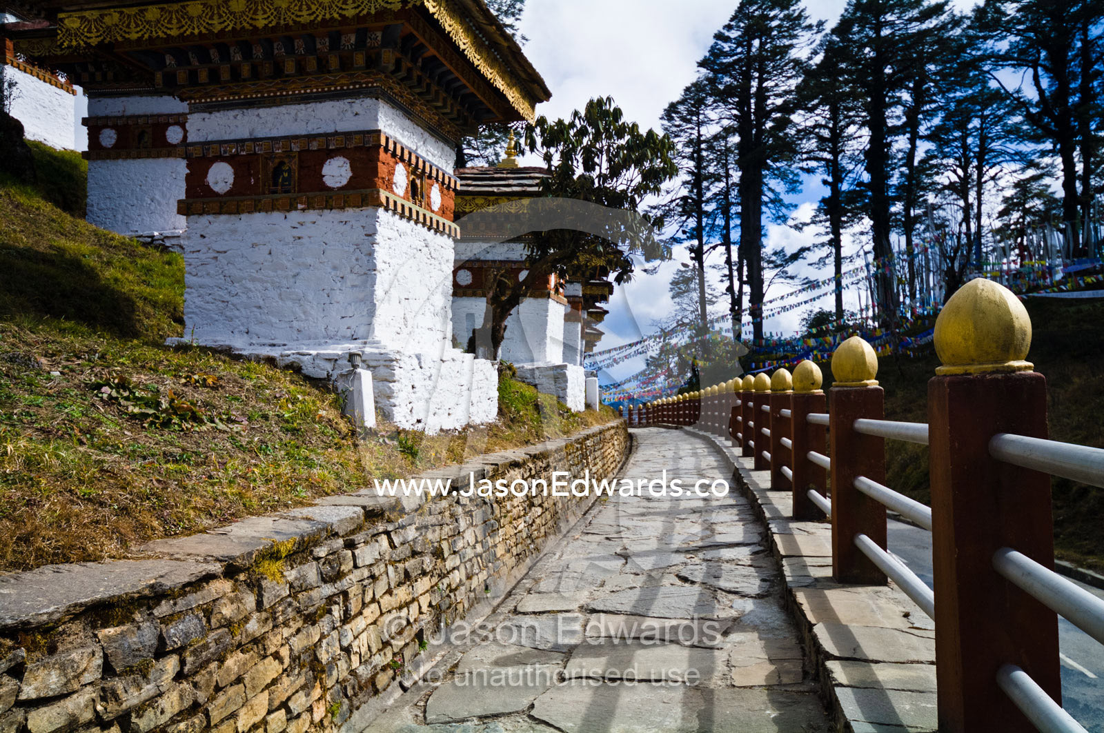 A stone paved walkway encircles a set of chortens on a mountain pass. 108 Druk Wangyal Khangzang Chortens, Dochula Pass, Thimphu District, Bhutan.
