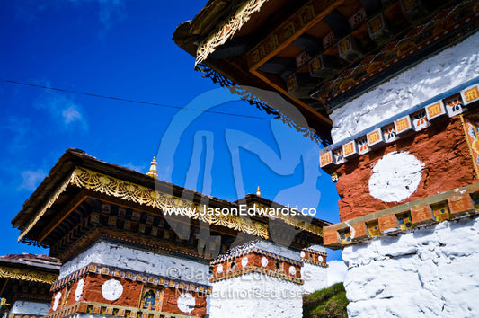Ornately decorated eaves beneath the tiled roofs of chortens. 108 Druk Wangyal Khangzang Chortens, Dochula Pass, Thimphu District, Bhutan.