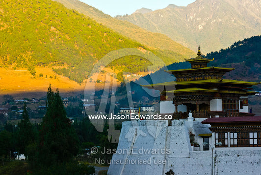 Sunset descends over a Himalaya valley casting shadows over an ancient Buddhist monastery. Punakha Dzong, Punakha dzongkhag, Punakha District, Bhutan.