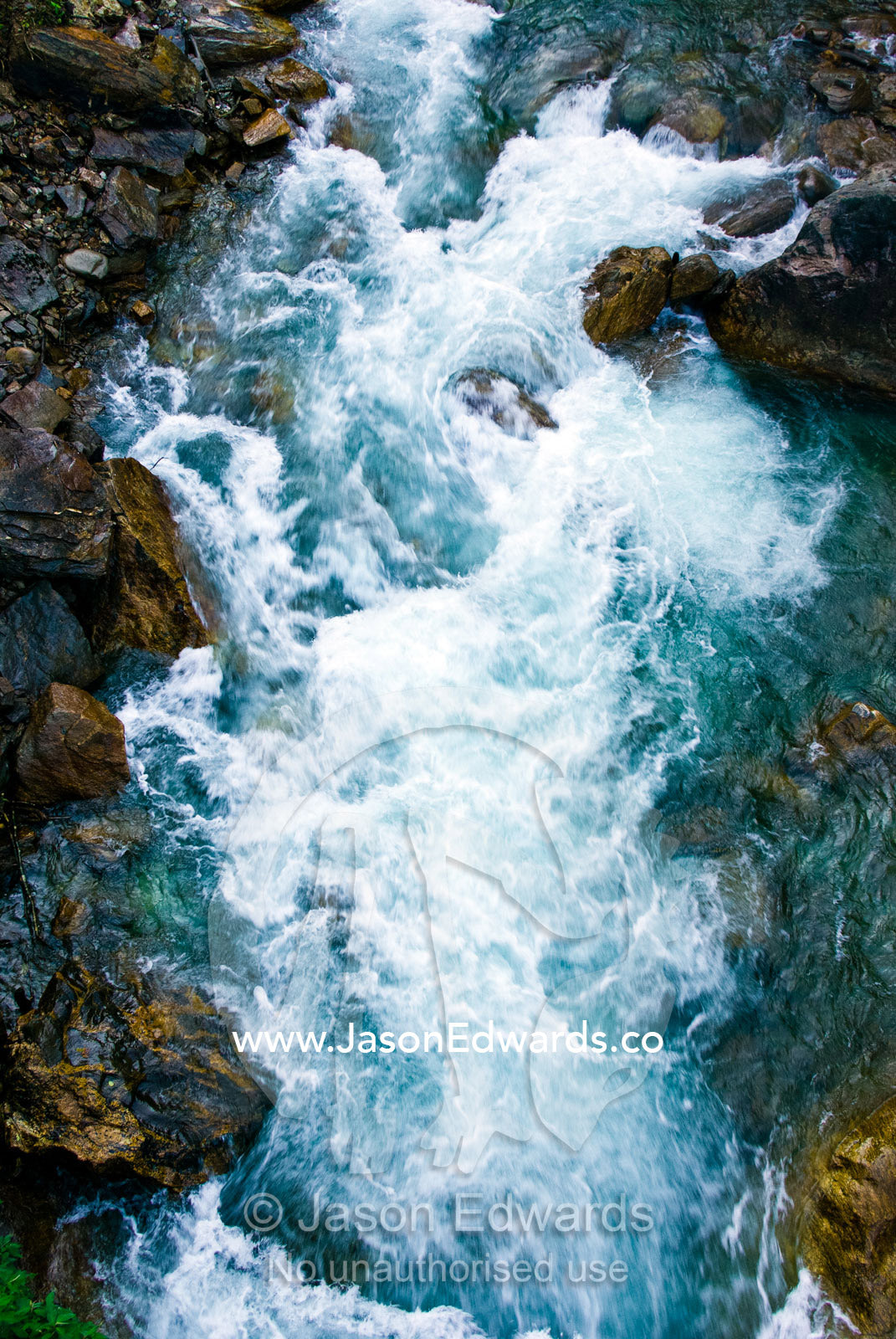 Icy water from snowmelt rushes through a mountain gorge between boulders in the Himalaya. Pho Chu, Pho River, Gasa Dzong, Gasa Tashi Tongmon Dzong, Gasa Gasa Dzongkhag District, Bhutan.