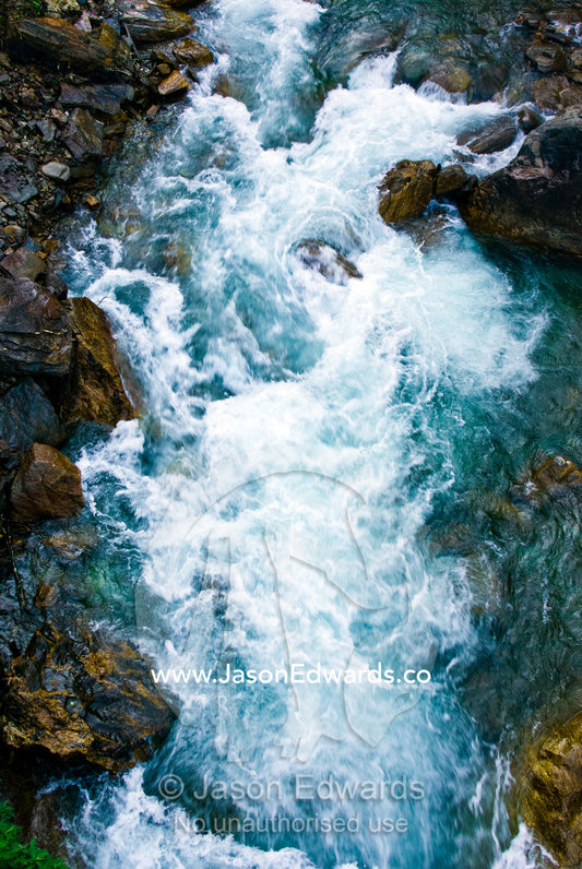Icy water from snowmelt rushes through a mountain gorge between boulders in the Himalaya. Pho Chu, Pho River, Gasa Dzong, Gasa Tashi Tongmon Dzong, Gasa Gasa Dzongkhag District, Bhutan.