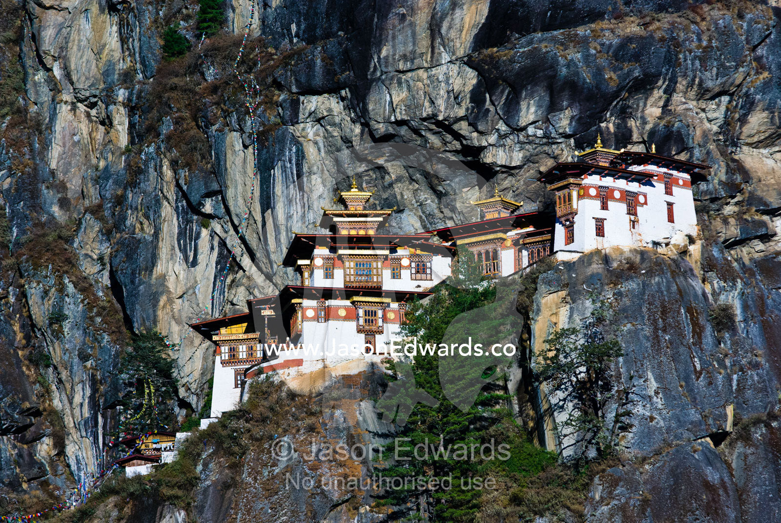 An ancient Buddhist monastery clinging to a sheer cliff on a Himalaya mountainside. Paro Taktsang, The Tigers Nest, Paro Valley, Paro District, Bhutan.