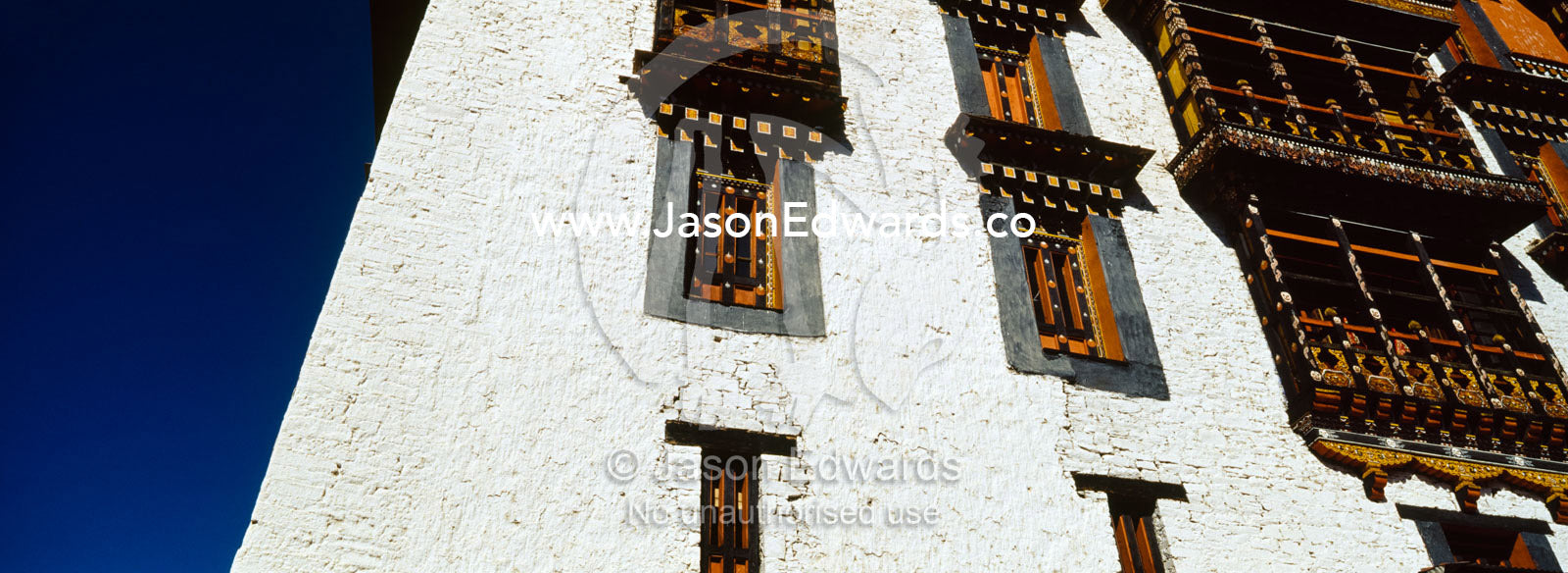 Ancient carved timber window shutters and balcony in a Buddhist monastery. Rinpung Dzong, Paro Dzong, Paro, Paro District, Bhutan.
