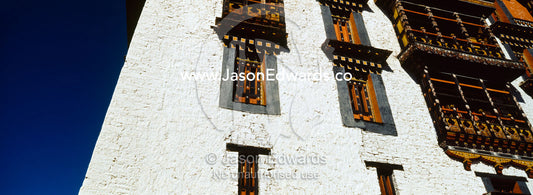 Ancient carved timber window shutters and balcony in a Buddhist monastery. Rinpung Dzong, Paro Dzong, Paro, Paro District, Bhutan.