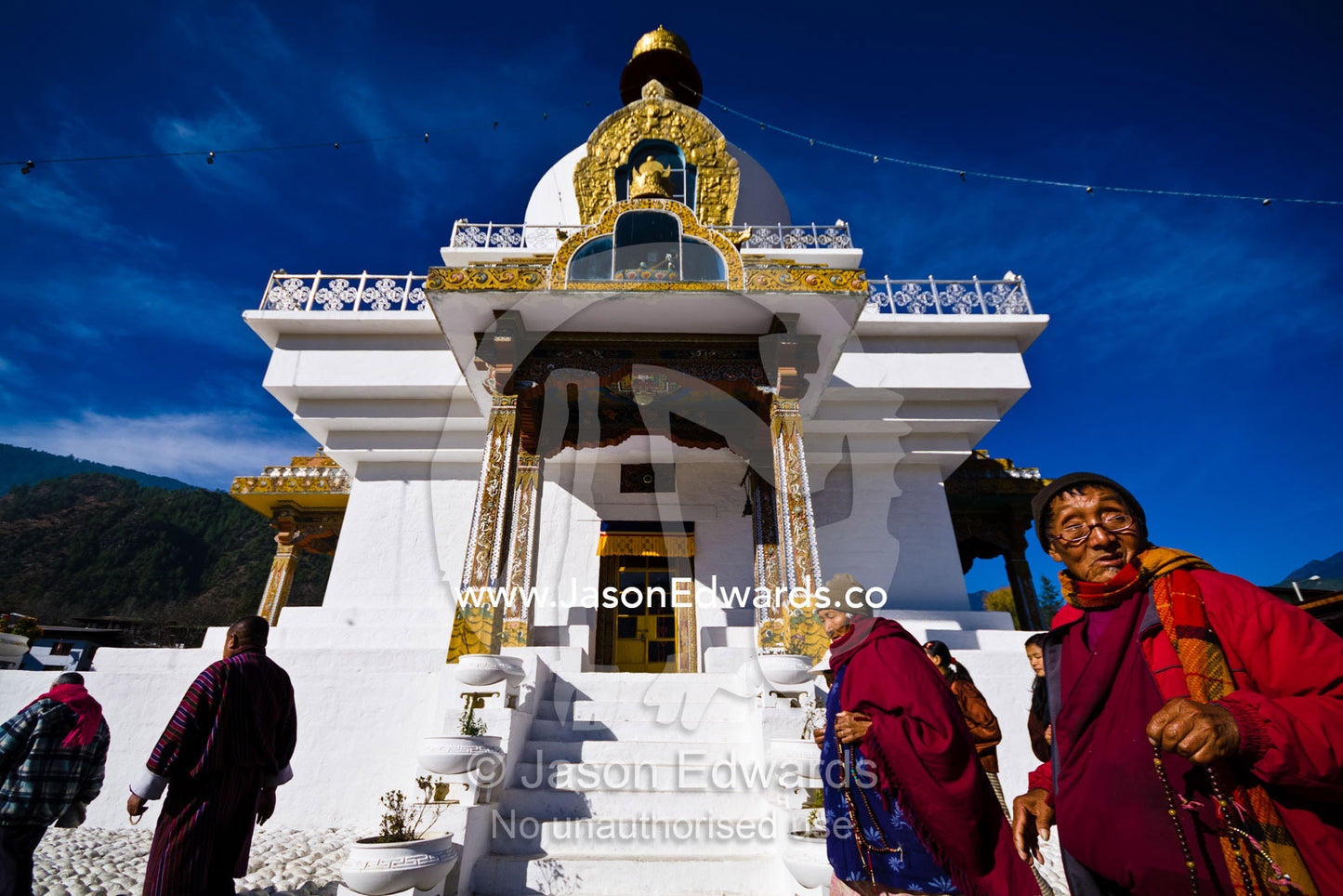 Elderly Buddhists walk in circles around the Memorial Chorten offering prayers and aspirations. Thimphu Memorial Chorten, Thimphu Bhutan.