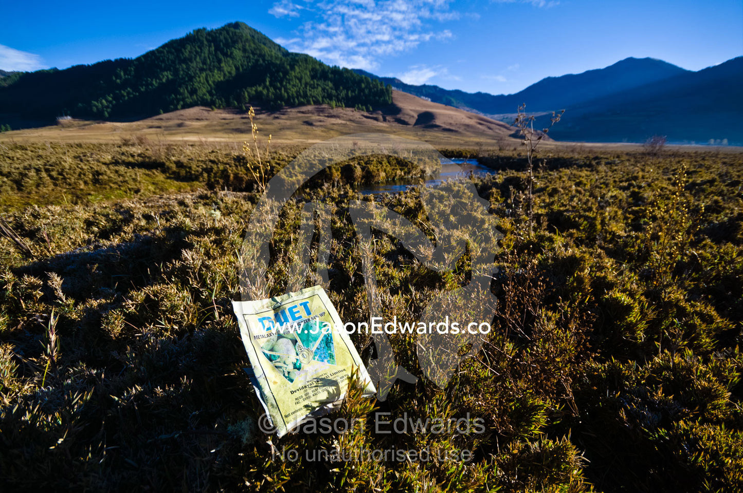 A discarded fungicide packet on a pristine alpine wetland indicates a threat of pollution. Phobjikha Conservation Area, Phobjika Valley, Phobjikha Valley, Gangteng Valley, Black Mountains, Bhutan.