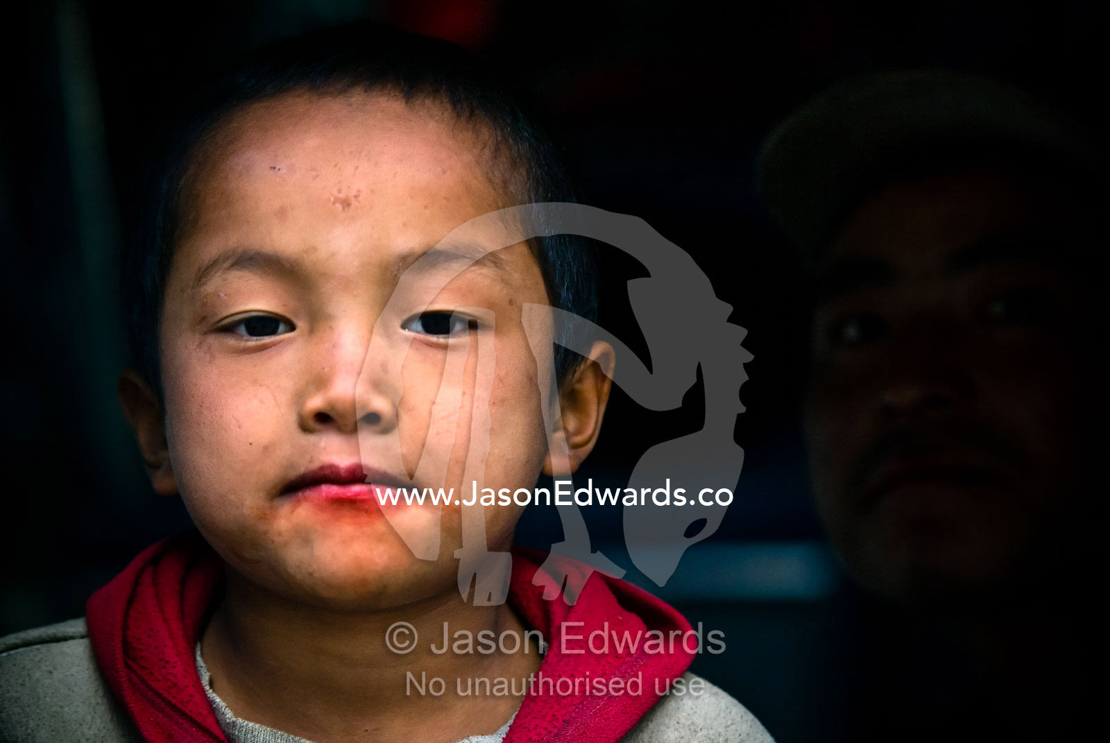A young boys with betel nut juice on his mouth. Wangdi, Wangdue Phodrang, Wangdue Phodrang District, Bhutan.