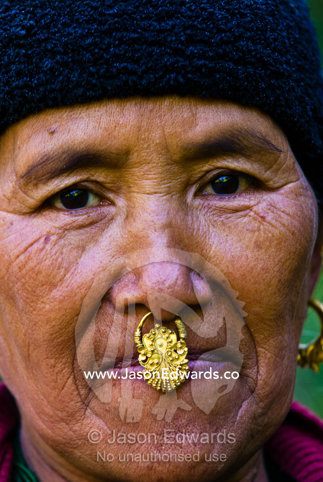 An elderly villager wearing an ornately carved gold nose ring. Jigme Dorji National Park, Gasa District, Bhutan.