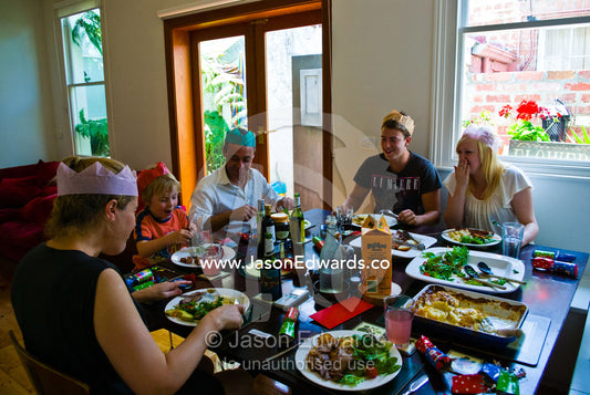 An excited boy receives a gift of money during Christmas lunch. Carlton North, Melbourne, Victoria, Australia.