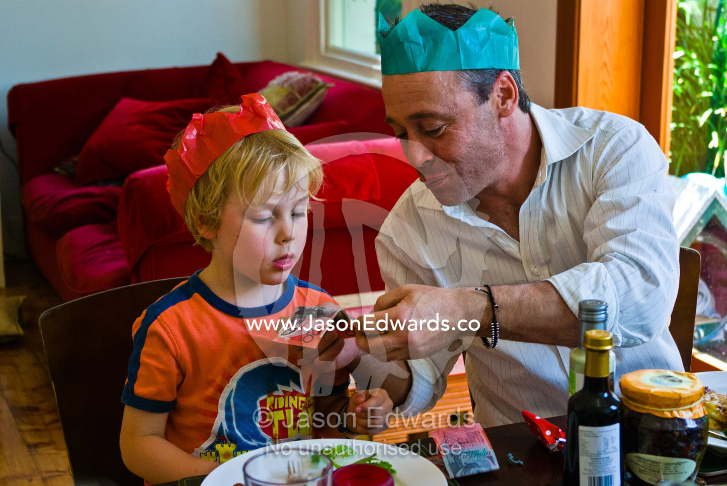 An excited boy receives a gift of money during Christmas lunch. Carlton North, Melbourne, Victoria, Australia.