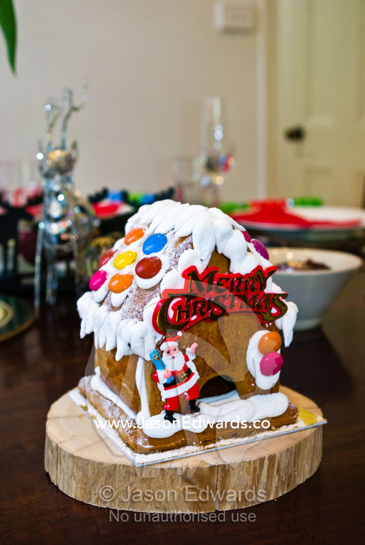 A gingerbread house with Father Christmas and snow candy roof. Carlton North, Melbourne, Victoria, Australia.