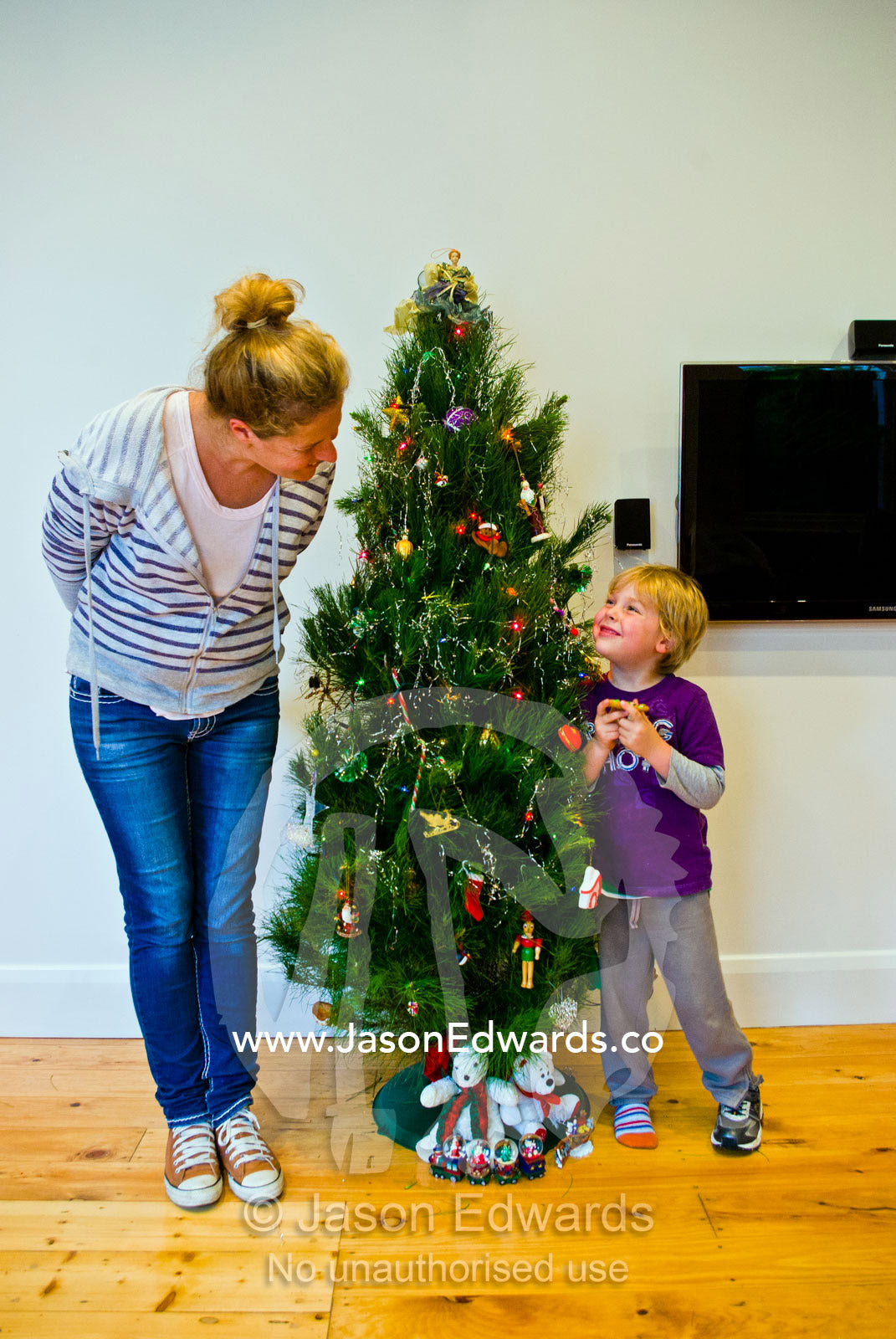 A mother and son decorates a family christmas tree in the living room. Carlton North, Melbourne, Victoria, Australia.