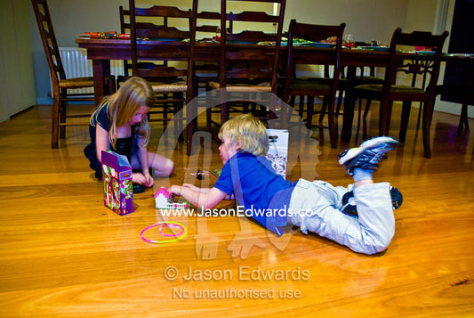 Children play with christmas gift toys on the dining room floor. Malvern East, Melbourne, Victoria, Australia.