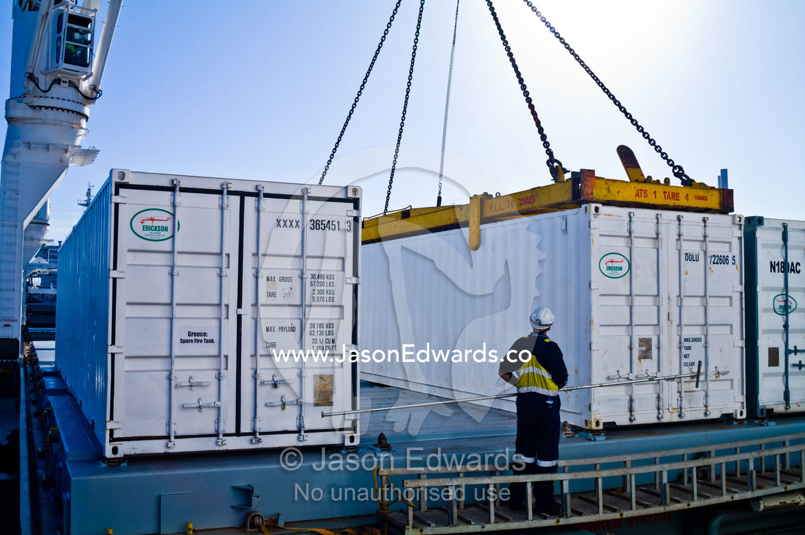 A cargo ships stevedore monitors a crane lifting shipping containers. Appleton Dock, Port of Melbourne, West Melbourne, Victoria, Australia.
