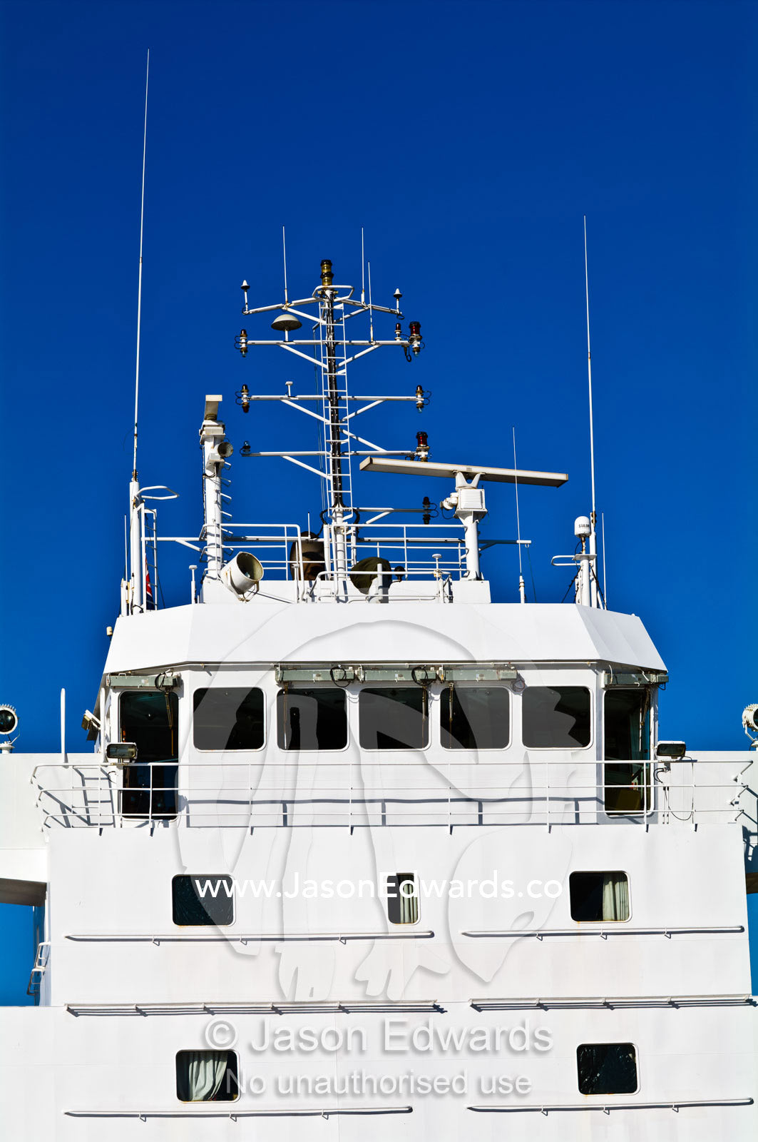 A cargo ship's bridge and control deck with antenna and spotlights. Appleton Dock, Port of Melbourne, West Melbourne, Victoria, Australia.