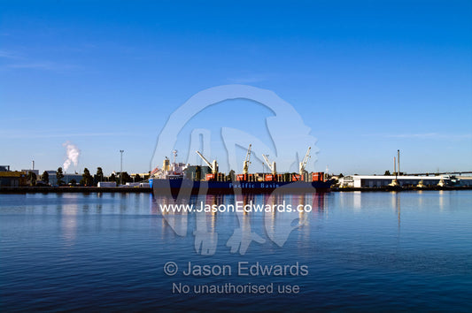 A cargo ship at a dock to be loaded with with shipping containers. Yarra River, Appleton Dock, Port of Melbourne, West Melbourne, Victoria, Australia.