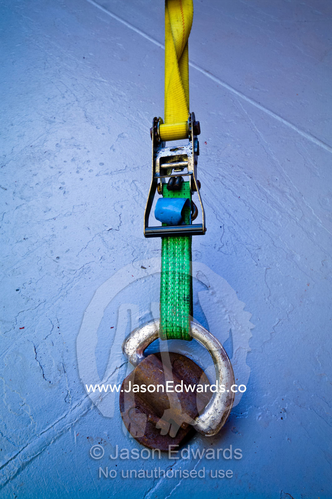 Ratchets fasten straps to a bracket on the floor of a cargo ship hold. Appleton Dock, Port of Melbourne, West Melbourne, Victoria, Australia.
