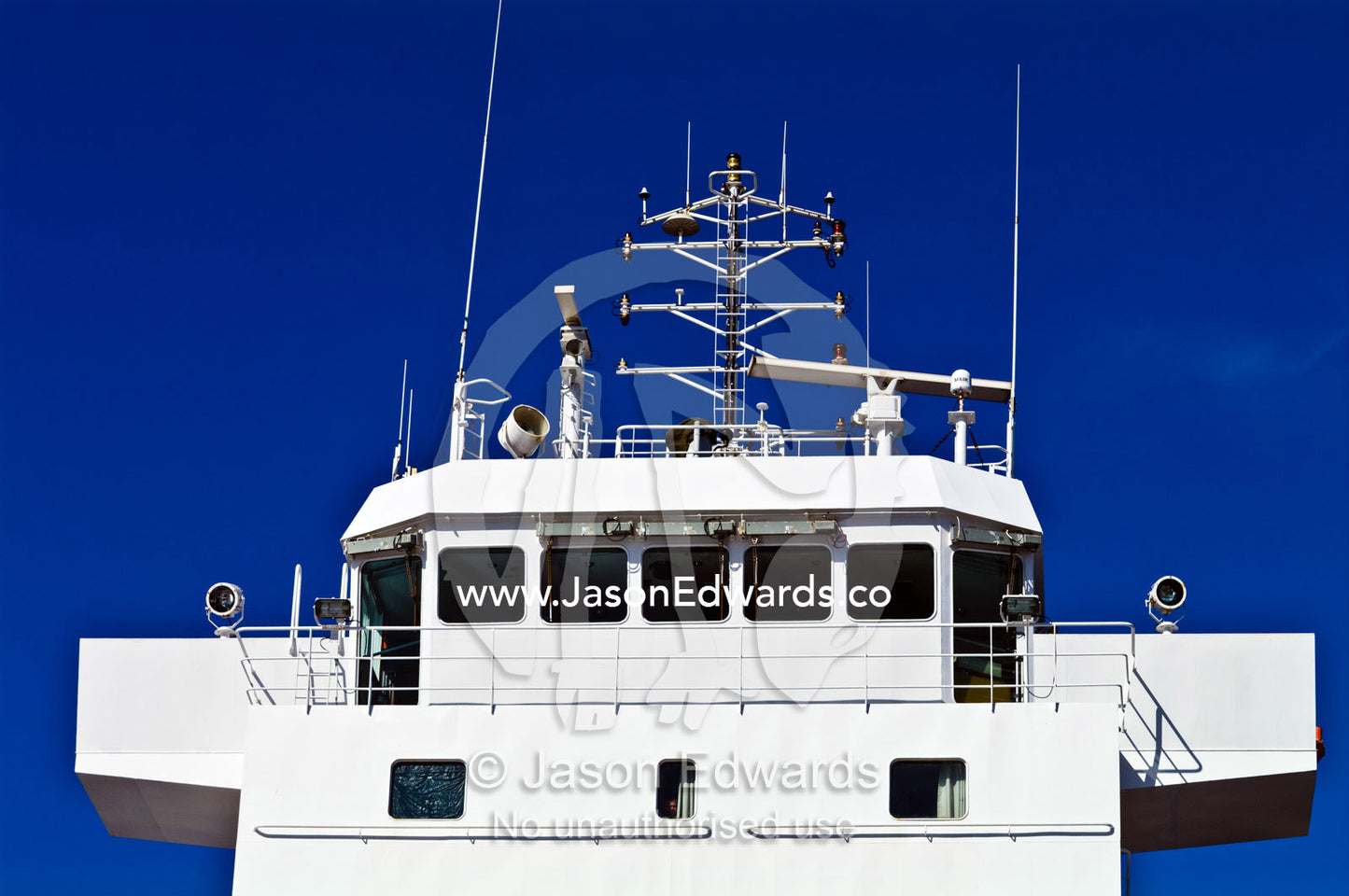 A cargo ship's bridge and control deck with antenna and spotlights. Appleton Dock, Port of Melbourne, West Melbourne, Victoria, Australia.