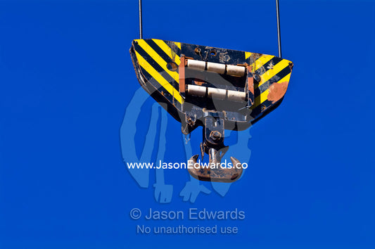 The steel hook of a cargo ships crane hangs over the deck cargo hold. Appleton Dock, Port of Melbourne, West Melbourne, Victoria, Australia.