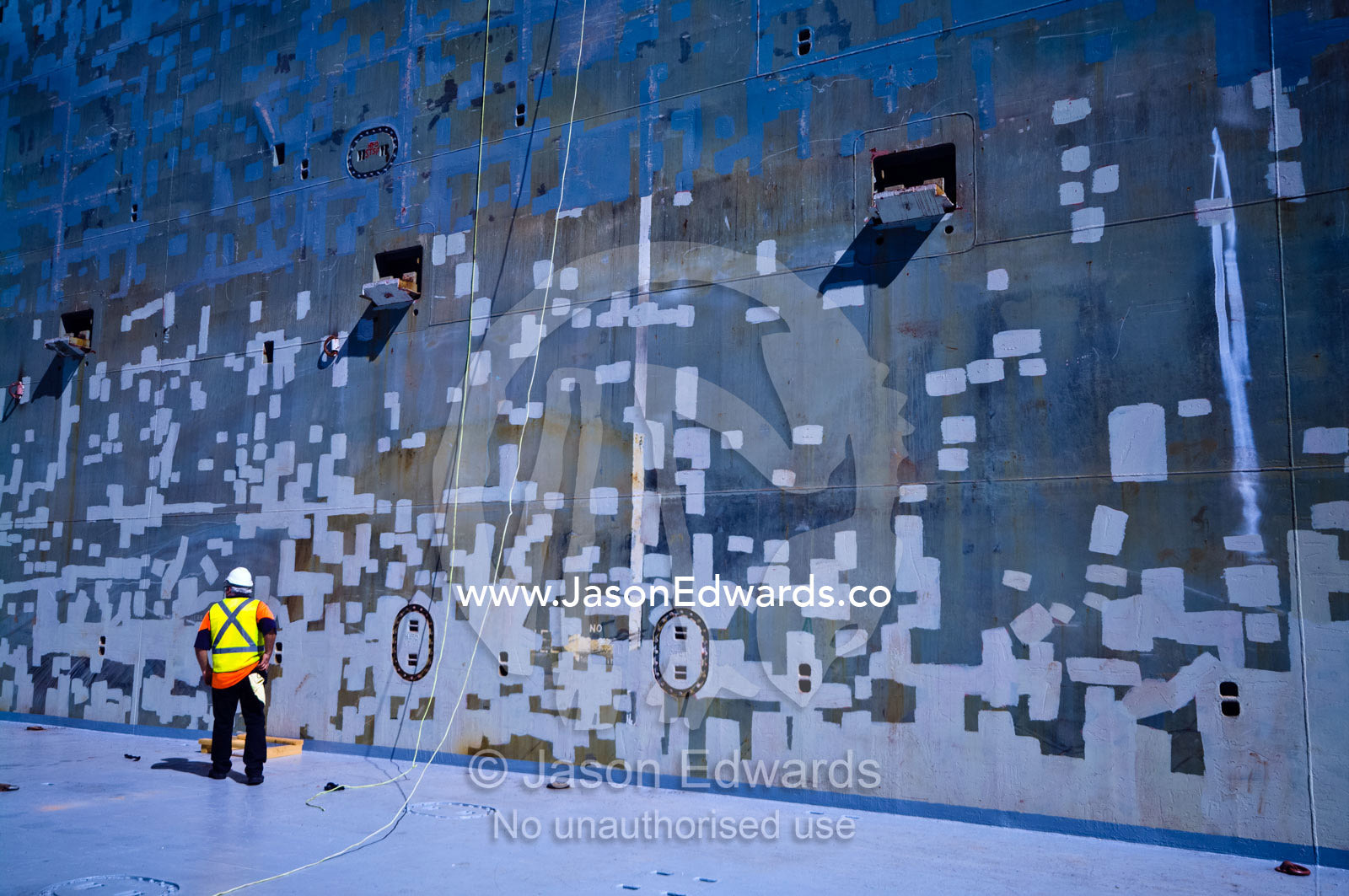 A stevedore inspects a ships cargo hold for steel corrosion. Appleton Dock, Port of Melbourne, West Melbourne, Victoria, Australia.