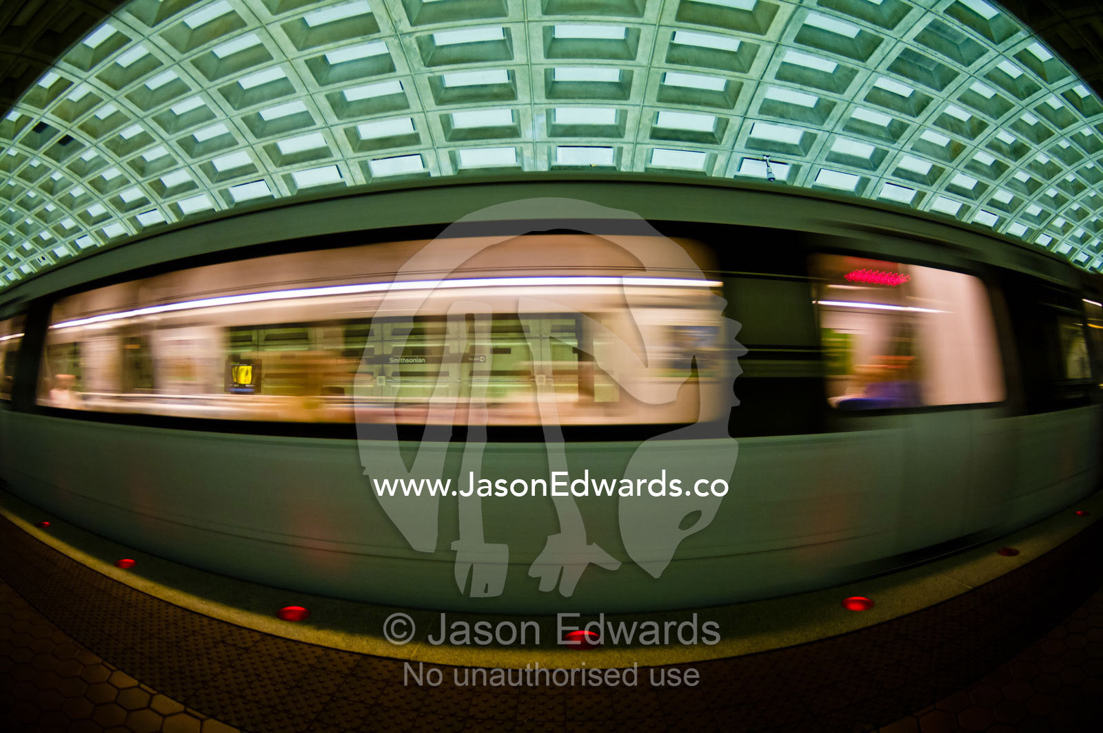 A Metro train speeds past a platform in a concrete subway tunnel. Washington Metropolitan Area Transit Authority, Washington, District of Columbia, United States of America.