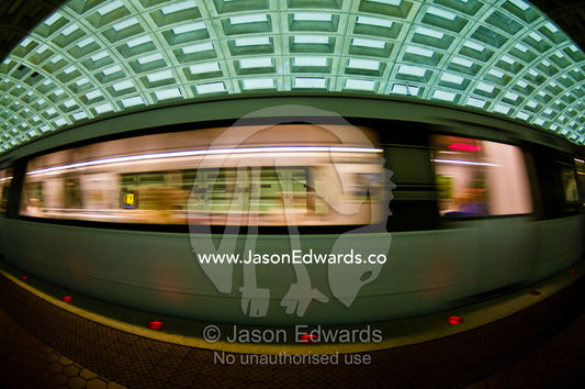 A Metro train speeds past a platform in a concrete subway tunnel. Washington Metropolitan Area Transit Authority, Washington, District of Columbia, United States of America.