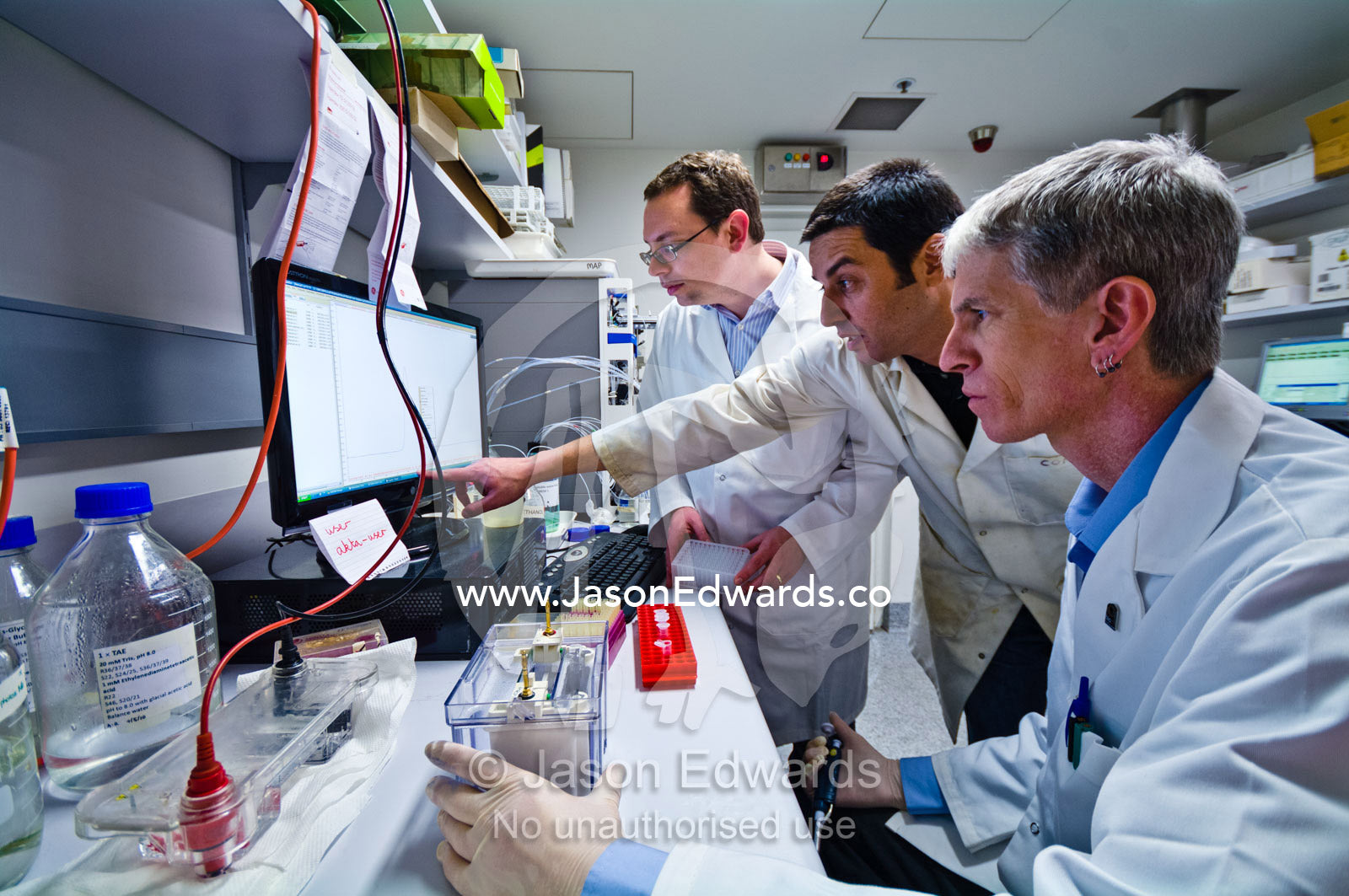 Scientists analyse data from a research experiment in a laboratory. Bio21 Molecular Science and Biotechnology Institute, University of Melbourne, Parkville, Melbourne, Victoria, Australia.