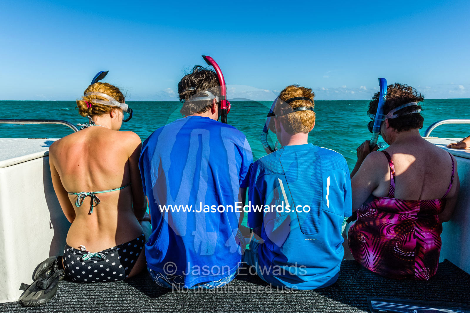 Tourists wait on the stern of a boat ready to dive with Whale Sharks. Exmouth, Ningaloo Reef, Ningaloo Marine Park, World Heritage Site, Western Australia, Australia.
