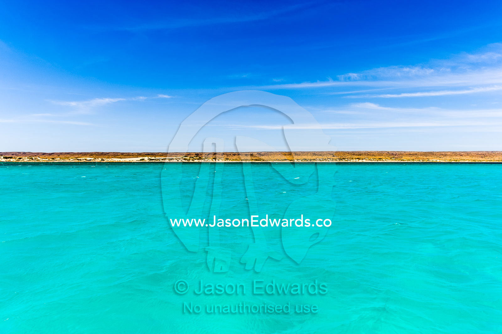 Clear turquoise tropical seas against an Outback desert coastline. Exmouth, Ningaloo Reef, Ningaloo Marine Park, World Heritage Site, Western Australia, Australia.