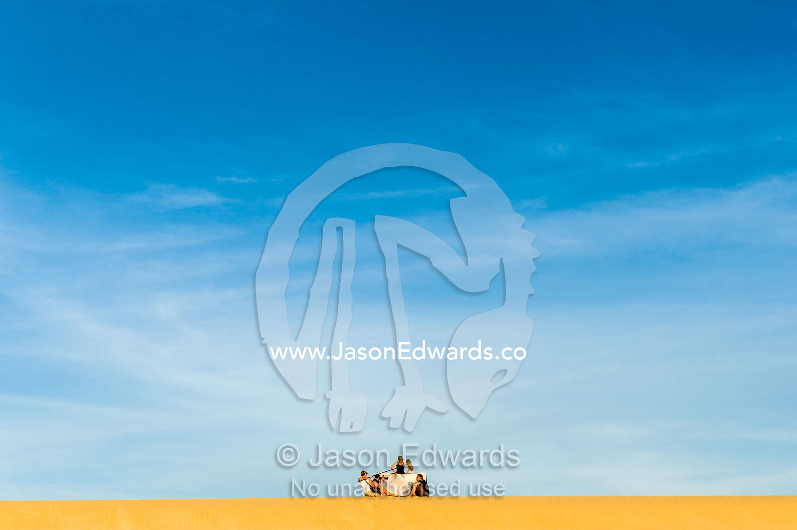 A film crew records an interview on a coastal sand dune at sunset. Cape Range National Park, Exmouth, Ningaloo Reef, Western Australia, Australia.