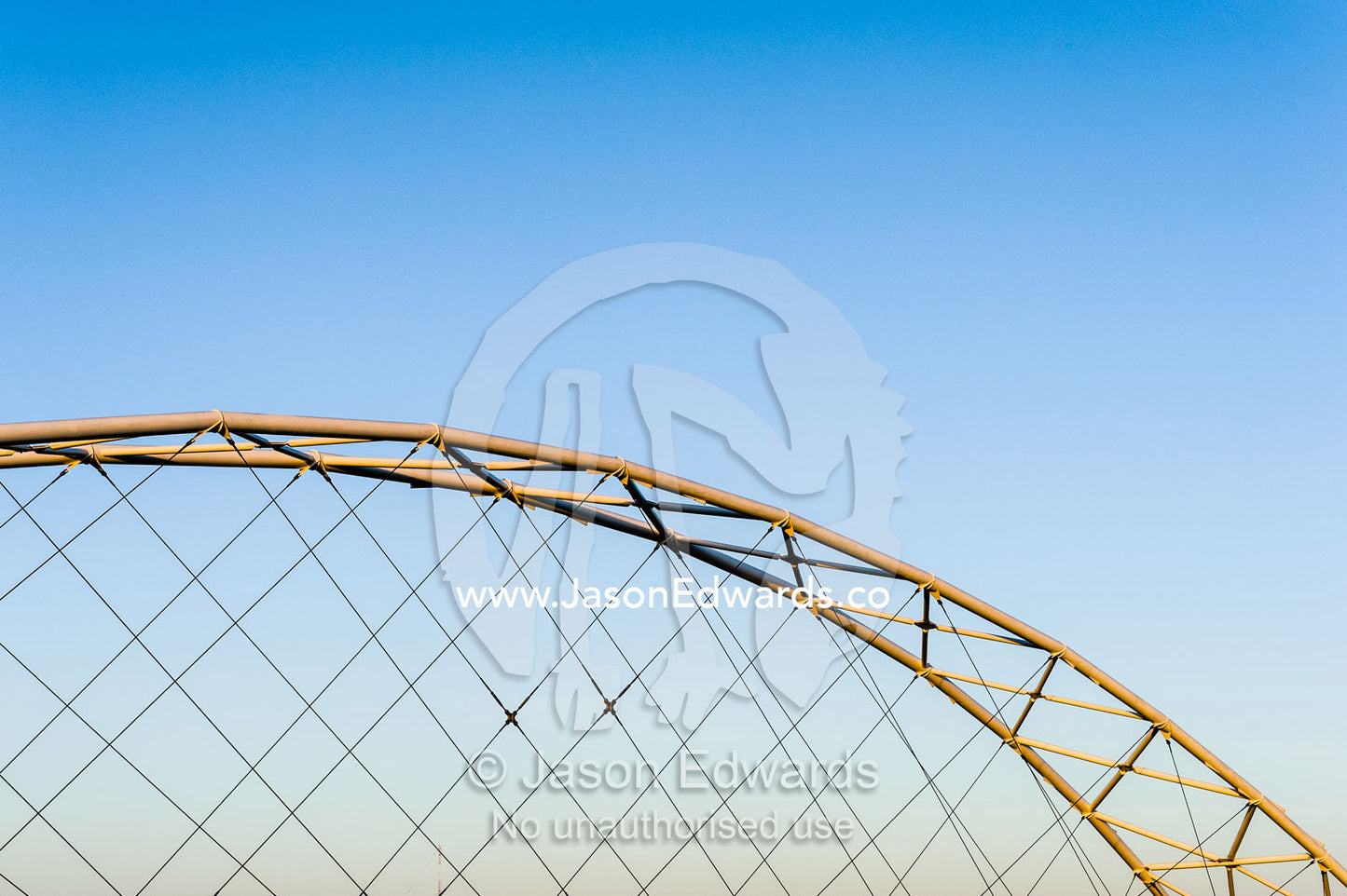 Steel girders of a residential foot bridge arching over a tidal canal. Exmouth, Ningaloo Reef, Western Australia, Australia.