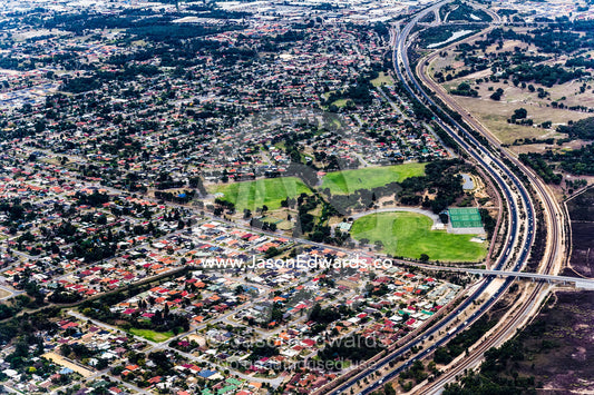 A highway snakes it's way around houses jammed in a suburban sprawl. Perth, Western Australia, Australia.