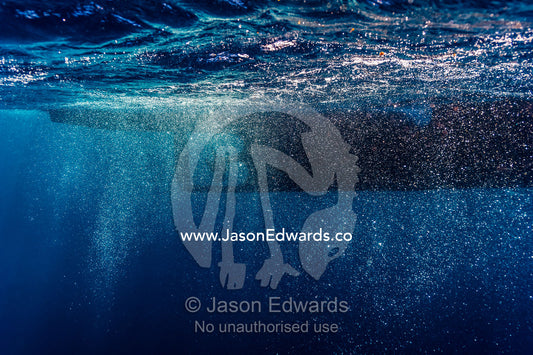 Bubbles swirling around a boat propeller below the ocean surface. Exmouth, Ningaloo Reef, Ningaloo Marine Park, Western Australia, Australia.