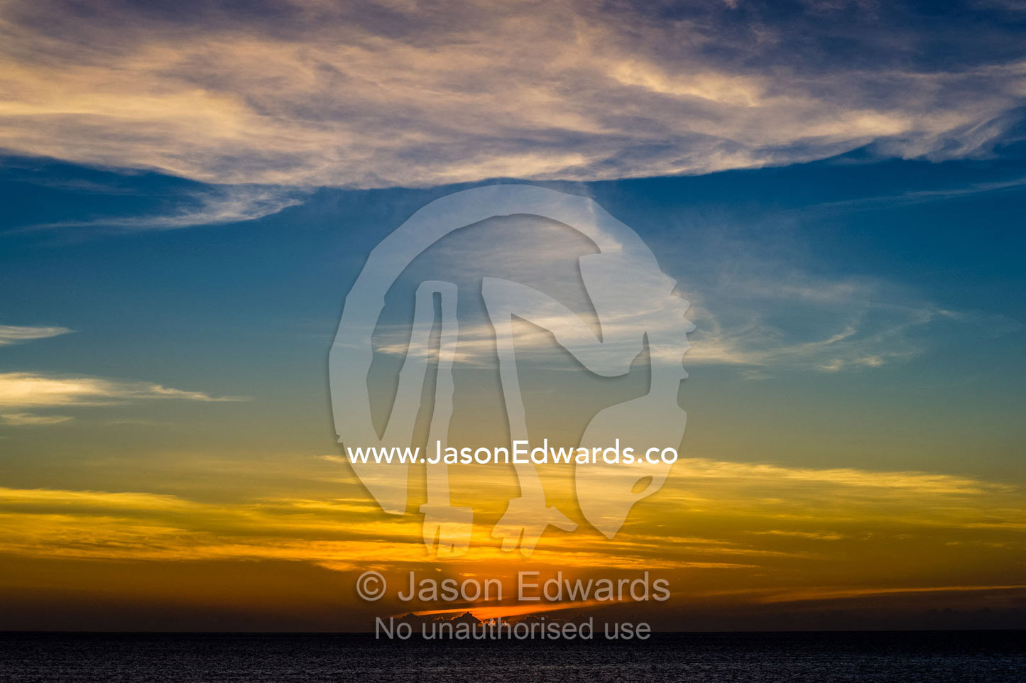 Sunset afterglow and pastel clouds over a calm tropical ocean. Cape Range National Park, Exmouth, Ningaloo Reef, Western Australia, Australia.