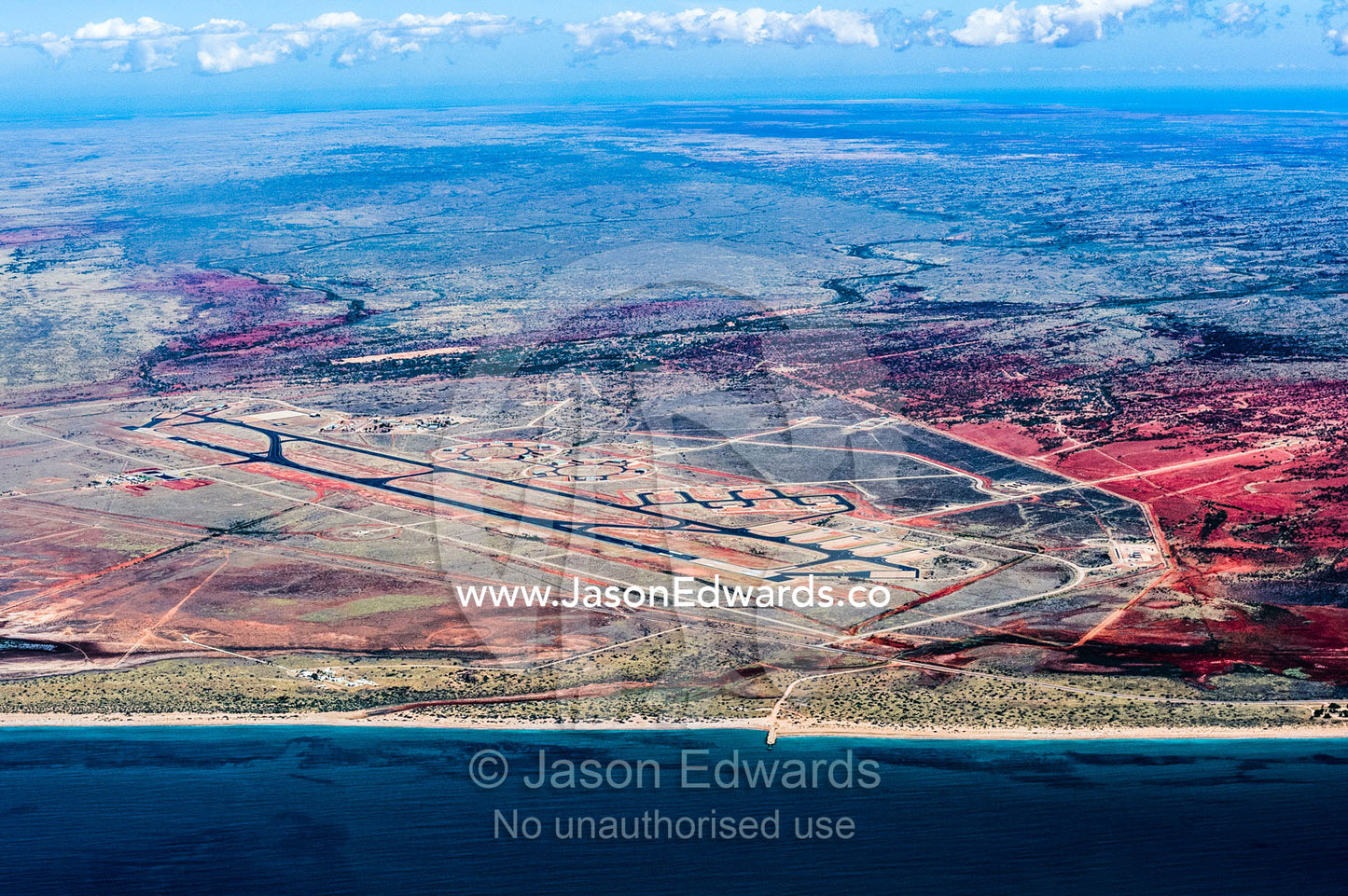 An aerial view of an airport and runway tarmac in a coastal desert. Exmouth, Ningaloo Reef, Western Australia, Australia.